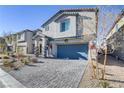 Two-story house with a gray facade, blue garage door, and landscaped front yard at 8351 Gold River Ct, Las Vegas, NV 89113