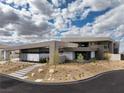 Modern home showcasing minimalist architecture, a desert landscape, and an inviting front entrance at 12 Chisel Crest Ct, Henderson, NV 89012