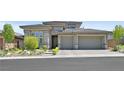 Charming exterior of two-story home features a three-car garage, desert landscaping, and a brick driveway at 12295 Skyracer Dr, Las Vegas, NV 89138