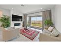 Living room with fireplace, sliding doors, and views of the backyard at 12295 Skyracer Dr, Las Vegas, NV 89138