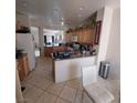 Bright kitchen featuring tile floors, a breakfast bar, and ample cabinet space with modern appliances at 4037 Gliding Gulls Ave, North Las Vegas, NV 89084