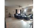 Spacious living room featuring tile flooring, ceiling fan, and a comfortable sectional sofa at 4037 Gliding Gulls Ave, North Las Vegas, NV 89084