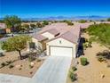 Single-story house with a two-car garage and desert landscaping at 3320 Kookaburra Way, North Las Vegas, NV 89084