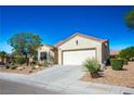 Tan house with a two-car garage and nicely landscaped front yard at 3320 Kookaburra Way, North Las Vegas, NV 89084