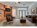 Virtually staged living room with brick fireplace and French doors at 1860 E Ford Ave, Las Vegas, NV 89123