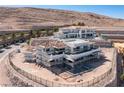 An aerial view of a luxury home under construction in a desert community, with scaffolding and mountain views at 12 Oakmont Hills Ln, Las Vegas, NV 89141