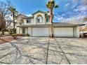 Two-story house with a three-car garage and paved driveway at 9917 Aspen Knoll Ct, Las Vegas, NV 89117