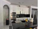 Modern kitchen showcasing an island with dark countertops and stainless steel double ovens at 2742 Kingclaven Dr, Henderson, NV 89044