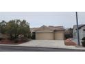 Attractive tan home with a terracotta roof and a spacious three-car garage at 1629 Black Fox Canyon Rd, Henderson, NV 89052