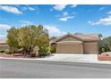 Inviting single-story home featuring a spacious three-car garage and meticulously maintained landscaping at 1629 Black Fox Canyon Rd, Henderson, NV 89052