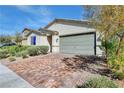Inviting single-story home with a brick driveway, manicured bushes and a two-car attached garage at 3716 W Colton Ave, North Las Vegas, NV 89032