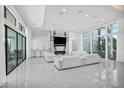Bright, open-concept living room with floor-to-ceiling windows, white sofas, and marble fireplace at 9760 Solar Ave, Las Vegas, NV 89149