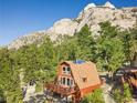 A-frame cabin with mountain views and solar panels, nestled in trees at 2196 Via Dulcedo St, Mount Charleston, NV 89124