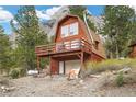 Two-story home with a garage and a balcony, nestled among lush greenery and views of the mountain at 2196 Via Dulcedo St, Mount Charleston, NV 89124