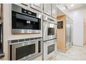 Modern kitchen featuring stainless steel appliances and custom cabinetry with a built-in coffee maker at 2349 Villandry Ct, Henderson, NV 89074