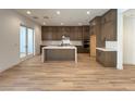 Gourmet kitchen featuring dark cabinets, an island, and stainless steel appliances at 9009 Shifting Skye St, Las Vegas, NV 89166