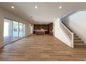 Expansive open-concept living space with wood floors and sliding glass doors at 9009 Shifting Skye St, Las Vegas, NV 89166
