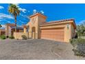 Tan two-story house with a two-car garage and a brick driveway at 1150 Calcione Dr, Henderson, NV 89011