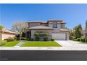 Charming two-story home features a well-manicured lawn, stylish landscaping, and attached two car garage at 17 Winding Rd, Henderson, NV 89052