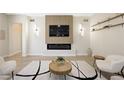 Living room area with a fireplace, mounted TV, and floating shelves at 17 Winding Rd, Henderson, NV 89052