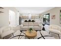 Open-concept living space with modern sofa, chairs and view to the kitchen at 17 Winding Rd, Henderson, NV 89052