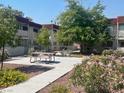 Exterior community shot with landscaped ground, picnic tables and walkways, and red brick apartment building at 5378 Swenson St # 21, Las Vegas, NV 89119