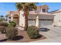 Two-story house with a two-car garage, palm trees, and well-manicured landscaping at 2196 Pescara Ct, Las Vegas, NV 89123