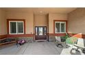 Covered front patio with seating and double door front entrance flanked by windows at 1120 W Gray Fox Way, Pahrump, NV 89048