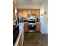 Traditional kitchen with wood cabinets, stainless steel appliances and tile flooring at 8216 Carmen Blvd, Las Vegas, NV 89128