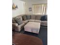 Comfortable living room featuring a sectional couch, ottoman, and large windows at 8216 Carmen Blvd, Las Vegas, NV 89128