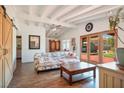 Cozy living room with beamed ceilings, barn door, wood floors and French doors to the yard at 16 Cerrito St, Blue Diamond, NV 89004