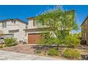 Charming two-story home featuring a brick driveway, two-car garage, and lovely landscaping at 6322 Highledge St, North Las Vegas, NV 89081