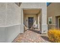 Inviting front porch featuring brick flooring and seating area at 6322 Highledge St, North Las Vegas, NV 89081