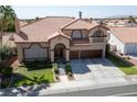 Two-story house with tile roof, three car garage, and landscaped yard at 8713 W Gilmore Ave, Las Vegas, NV 89129