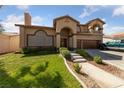 Two story house with tile roof, three car garage and landscaped yard at 8713 W Gilmore Ave, Las Vegas, NV 89129