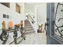 Elegant entryway with a glass-top table and staircase at 7646 Sandhaven St, Las Vegas, NV 89139