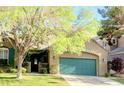 Charming home featuring a green garage door, front yard, and mature trees at 9809 Miss Peach Ave, Las Vegas, NV 89145