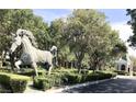 Outdoor horse statue with manicured hedges and trees in the Queensridge community at 9809 Miss Peach Ave, Las Vegas, NV 89145