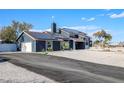 Contemporary home with dark siding, solar panels, a spacious driveway, and low-maintenance landscaping at 7135 Polaris Ave, Las Vegas, NV 89118