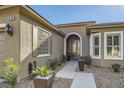 Close up on the front entrance and walkway, featuring an arched doorway, and decorative landscaping at 10315 Premia Pl, Las Vegas, NV 89135