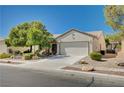 Inviting single-Gathering home with desert landscaping, a concrete driveway, and a white garage door at 7457 Widewing Dr, North Las Vegas, NV 89084