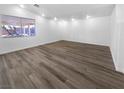 Spacious living room with wood-look floors, bright white paint and ample natural light at 1195 Sunfire St, Henderson, NV 89014