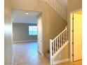 Two-story entryway with wooden staircase and tiled floors at 9902 Belikove Manor Ave, Las Vegas, NV 89178