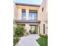 Stunning home entrance with modern architecture, a tiled walkway, and beautiful landscaping, perfect for outdoor relaxation at 4915 Summit Overlook Dr, Las Vegas, NV 89135