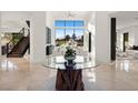Bright foyer with a glass table, stone base, and view of the backyard, complemented by a staircase at 73 Princeville Ln, Las Vegas, NV 89113