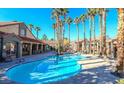 Community pool with palm trees and lounge chairs at 2300 E Silverado Ranch Blvd # 1165, Las Vegas, NV 89183