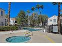 Relaxing pool and spa area with palm trees and comfortable lounge chairs at 4860 Nara Vista Way # 104, Las Vegas, NV 89103