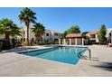 Beautiful community pool surrounded by palm trees and well-maintained landscaping at 4860 Nara Vista Way # 104, Las Vegas, NV 89103
