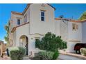 Inviting stucco home with an arched entry, attached garage, and carefully landscaped front yard at 6271 Sunset Spring Ave, Las Vegas, NV 89122