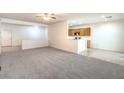 Open living space features neutral carpeting, an adjacent breakfast bar, and easy kitchen access at 7625 Fieldfare Dr, North Las Vegas, NV 89084